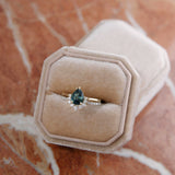 Diamond eternity wedding band and 14k yellow gold engagement ring with teal green sapphire and a half-halo of diamonds