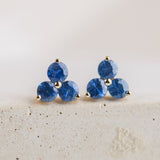 14k yellow gold stud earrings with 3 blue sapphires arranged in a floral shape