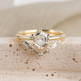 Hexagon diamond engagement ring 14k yellow gold solitaire setting with six prongs, paired with a v shaped wedding band that features 4 baguette and 5 round diamonds