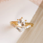 Modern hexagon diamond engagement ring 14k yellow gold solitaire setting with six prongs, paired with a v shaped wedding band that features 4 baguette and 5 round diamonds