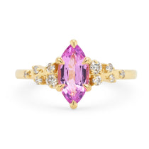 14k yellow gold engagement ring with a bright pink marquise sapphire surrounded by scattered white diamonds